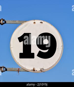 Rundes Straßenbanner mit der Nummer 19 im Hintergrund des Himmels. Stockfoto