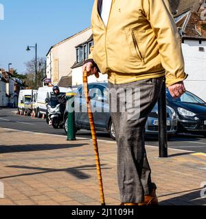 Epsom Surrey London, UK, März 21 2022, Senior Seniorer man Crossing Road mit Walking Stick Stockfoto