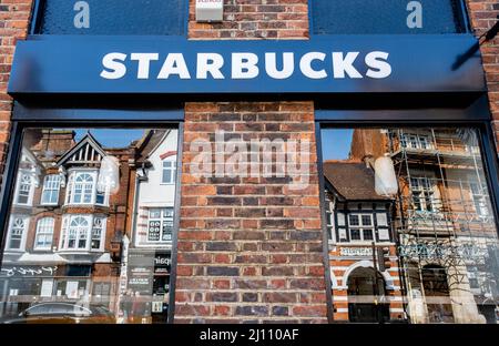 Epsom Surrey London, Großbritannien, März 21 2022, Starbucks High Street Coffee Shop Schild und Fenster, die gegenüber den High Steet Gebäuden spiegeln Stockfoto
