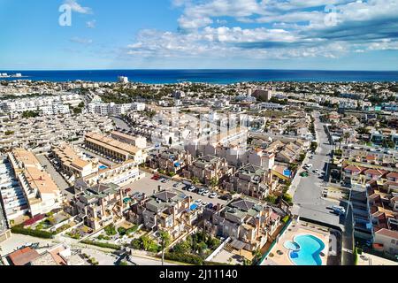 Wohnviertel Stadtbild Dächer von Cabo Roig Luftbild Küste spanische Stadt, Mittelmeer und blau bewölkten Himmel an sonnigen Sommertag. Stockfoto