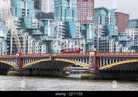 Blick auf London; Ein London Bus überquert die Themse über die Vauxhall Bridge vor moderner britischer Architektur, Vauxhall, London UK Stockfoto