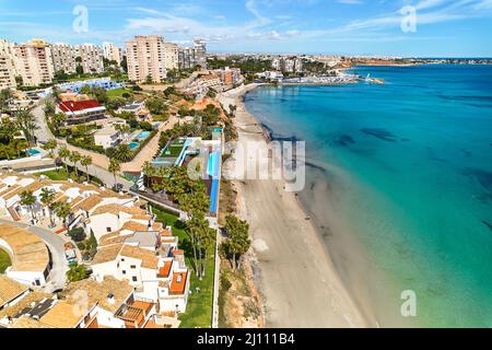 Drohne aus der Vogelperspektive Dehesa de Campoamor Stadtbild mit Sandstrand, spanisches Resort an der Costa Blanca. Reise- und Tourismuskonzept, Provinz o Stockfoto