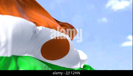 Detail der Nationalflagge Nigers, die an einem klaren Tag im Wind winkt. Niger ist ein Binnenland in Westafrika. Selektiver Fokus. Stockfoto