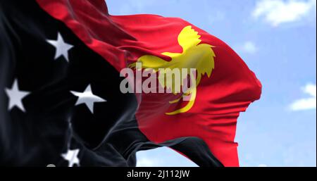 Detail der Nationalflagge von Papua-Neuguinea, die an einem klaren Tag im Wind winkt. Papua-Neuguinea ist das drittgrößte Inselland der Welt. Auswahl Stockfoto