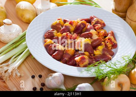 Rohe Hühnerherzen mit frischem Gemüse Stockfoto