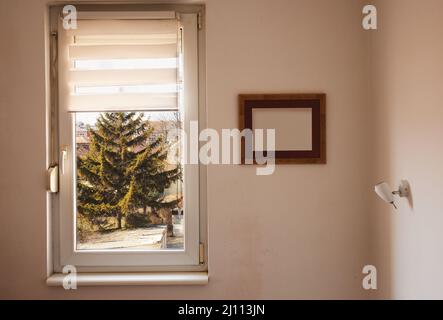 Eine Ecke eines Heims, Fenster und Rahmen an der Wand während des Tages. Stockfoto