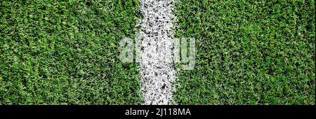 Ein Teil des Fußballfeldes aus der Nähe, künstliches grünes Gras mit weißen Randlinien, Astroturf im Stadion für Sportenspiele Stockfoto