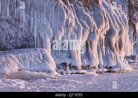 Schöner Winterhintergrund mit gefrorenen Wasserstrahlen im Sonnenuntergang Licht Stockfoto