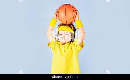 Kleiner Basketballspieler. Kind in Sportkleidung wirft Ball. Basketballtraining. Aktiver Sport-Lifestyle. Stockfoto