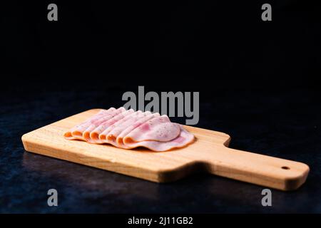 Scheiben Wurst Mortadella und Zwiebel auf einem Schneidebrett Stockfoto
