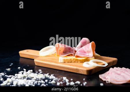Scheiben Wurst Mortadella und Zwiebel auf einem Schneidebrett Stockfoto