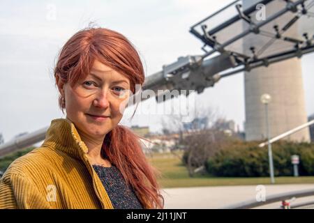 Porträt einer jungen rothaarigen Frau mit blauen Augen, die die Kamera anschaut Stockfoto