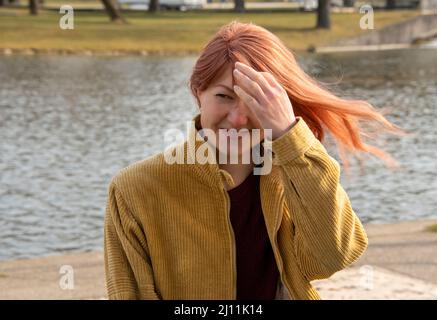 Porträt eines rothaarigen Lachens, mit einer Hand vor dem Gesicht Stockfoto
