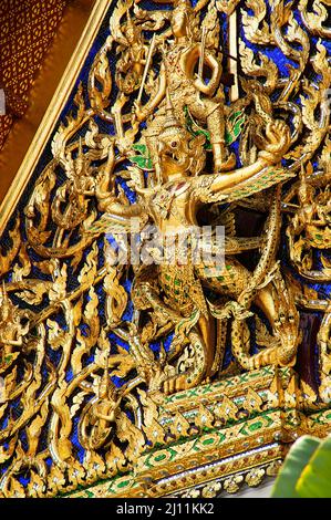 Detailansicht der Schnitzereien am Großen Palast; พระบรมมหาราชวัง; Wat Phra Kaew, Bangkok, Thailand. Goldener gebettender Buddha Stockfoto