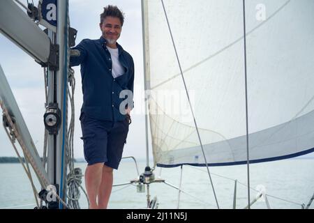 Porträt eines selbstbewussten, reifen Alters, mittleren Alters, eines Mannes mit mittlerem Erwachsenenalter im Jahr 50s, glückliches Lächeln. Im Freien, Seemann an Bord des Segelbootes, Stockfoto