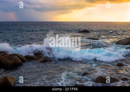 Seascape bei Sonnenuntergang. Wellen schlagen gegen die Felsen an der Küste. Stockfoto