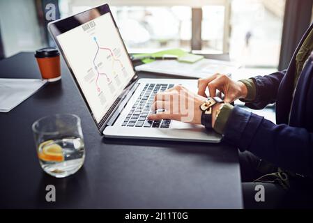 Die Planung hilft ihr, ihre Ziele zu erreichen. Eine ausgeschnittene Aufnahme einer nicht identifizierbaren Geschäftsfrau, die ihren Laptop an ihrem Schreibtisch benutzt. Stockfoto