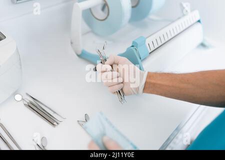 Zahnarzthelfer Sterilisieren und Verpacken von Zahnarztgeräten in Sterilisationsbeuteln aus Kunststoff Stockfoto
