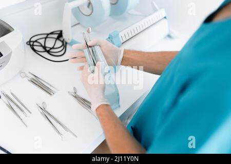 Zahnarzthelfer Sterilisieren und Verpacken von Zahnarztgeräten in Sterilisationsbeuteln aus Kunststoff Stockfoto