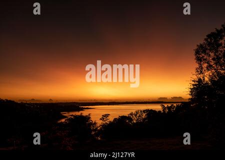 Silhouette von Bäumen mit einem schönen Sonnenaufgang in Anchieta, Bundesstaat Espirito Santo, Brasilien Stockfoto