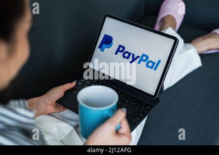 CHIANG MAI, THAILAND - MÄR 18 2021 : Frau mit iPad mit paypal-Logo auf dem Bildschirm. PayPal ist ein weltweites Online-Zahlungssystem und eines der am meisten Stockfoto
