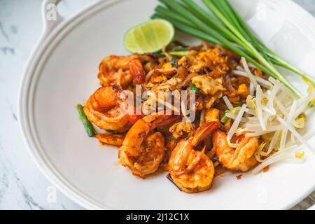 Garnelen Pad Thai oder traditionelle Thai Nudelmenü, Pad Thai in stilvoller runder Form auf einem Marmortisch, Nahaufnahme Thai Essen. Stockfoto