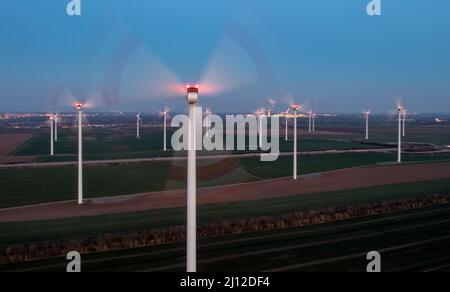 21. März 2022, Sachsen-Anhalt, Bad Lauchstädt: Windturbinen rotieren nahe der Autobahn 143, im Hintergrund die Kühltürme des Braunkohlekraftwerks Schkopau. Die kriegerischen Auseinandersetzungen beleben die Diskussion in Deutschland über den Ausstieg aus Braunkohle und den Ausbau erneuerbarer Energien. (Luftaufnahme mit Drohne) Foto: Jan Woitas/dpa-Zentralbild/dpa Stockfoto