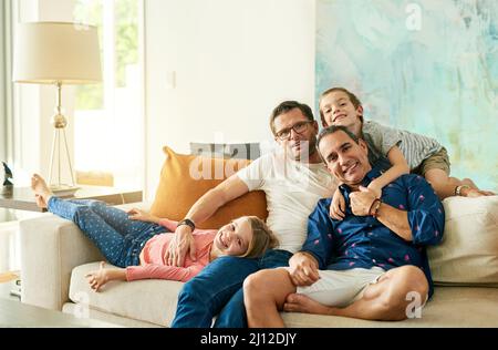 Waren eine glückliche Familie. Beschnittenes Porträt einer liebevollen vierköpfigen Familie auf dem Sofa zu Hause. Stockfoto