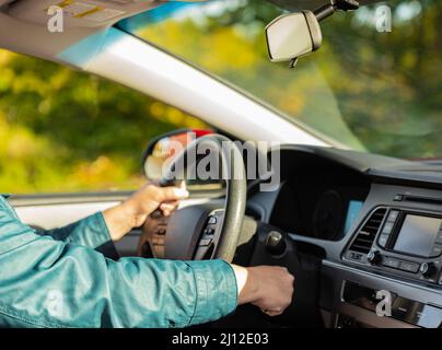 Nahaufnahme der Hand einer Person, die den Schlüssel zum Start des Fahrzeugs einführt. Verschwommenes Foto, selektiver Fokus Stockfoto