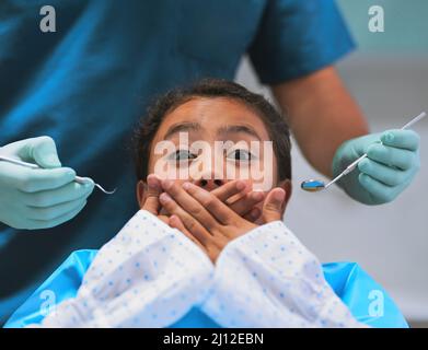 Ich glaube nicht, dass ich dafür bereit bin. Aufnahme eines verängstigten kleinen Mädchens, das auf einem Zahnarztstuhl liegt und ihren Mund geschlossen hält, um den Zahnarzt vor dem zu bewahren Stockfoto