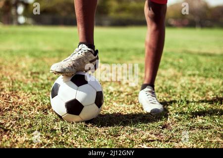 In diesem Spiel müssen Sie schnell auf den Beinen sein. Nahaufnahme eines Jungen, der auf einem Sportplatz Fußball spielt. Stockfoto