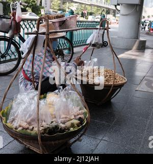 Die Verkäuferin an der Straße verkauft Hot Corn Cobs und Hot Peanuts auf dem Bürgersteig in Bangkok, Thailand Stockfoto