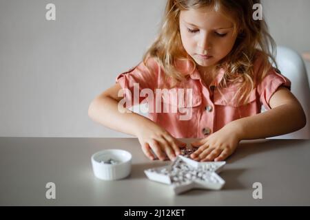 Nettes kleines blondes Mädchen ist in der Kreativität tun Handwerk engagiert Stockfoto