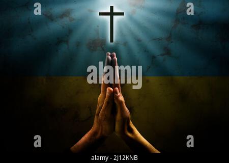 Hände im Gebet. Gebet für die Ukraine. Ukrainische Flagge. Gebet für die ganze Welt Stockfoto