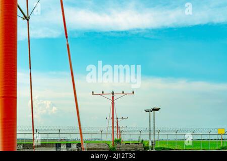 Anflugscheinwerfer am Flughafen. Konzept des Approach Light-Systems. Anflugscheinwerfer für die Landebahn des Flughafens. ALS des Flughafens. Zaun für Sicherheit. Landschaft Stockfoto