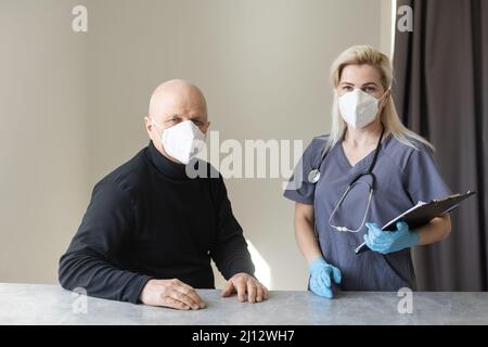 Arzt und älterer Mann mit Gesichtsmasken während des Coronavirus- und Grippeausbruchs. Schutz vor Viren und Krankheiten, Quarantäne zu Hause. COVID-2019. Stockfoto