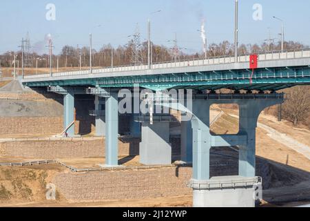 Eine Straßenbrücke über den Fluss. Strukturen der Automobilbrücke von unten Stockfoto