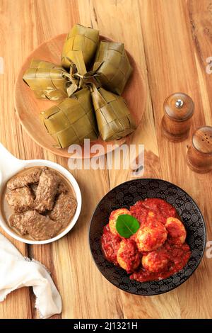 Ketupat, Rendang und Telur Balado, Draufsicht auf Holztisch. Menü Lebaran Gericht Stockfoto