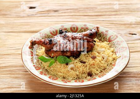 Chicken Kabsa mit Basmati-Reis auf Holztisch Stockfoto