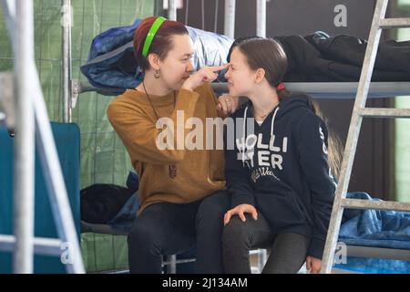 Bad Kreuznach, Deutschland. 21. März 2022. Daria (l) versucht, ihre Schwester Bohdana aufzumuntern, indem sie der Elfjährigen die Stirn kitzelt. Die 19-jährige Ukrainerin ist zusammen mit ihrer Mutter und ihren beiden Schwestern im Notheim in Bad Kreuznach untergebracht. (To dpa-Korr 'Horrormomente sind auch in Bad Kreuznach allgegenwärtig') Quelle: Boris Roessler/dpa/Alamy Live News Stockfoto