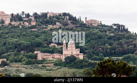 Heiligtum der Madonna di San Biagio umgeben von Wald und Montepulciano Stadt hinter auf dem Hügel, Siena, Italien Stockfoto