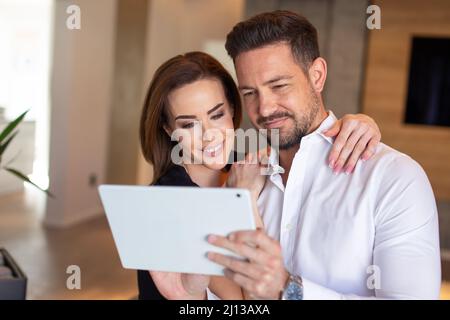Happy 30s Kaukasisches Paar Online-Shopping mit digitalem Tablet zu Hause Stockfoto