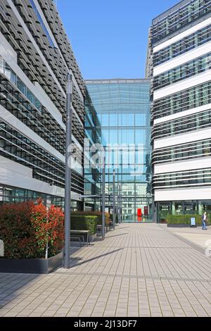 Düsseldorf (Vodafone Campus) – März 9. 2022: Blick über den Platz auf moderne Gebäude, Glasfront gegen blauen Himmel Stockfoto