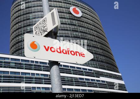 Düsseldorf (Vodafone Campus) – März 9. 2022: Blick auf Pfeilrichtungsschild gegen modernen Turm und klaren blauen Himmel Stockfoto