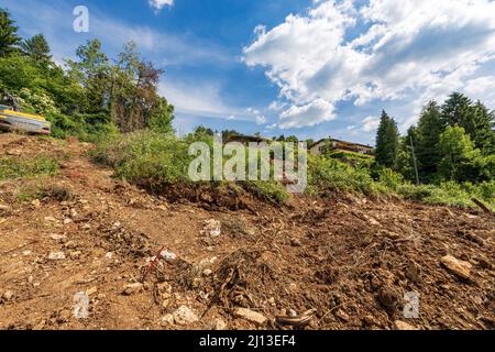 Entwaldung und Ausgrabungen für den Bau neuer Häuser in den Bergen, italienischen Alpen, Italien, Europa. Konzept für Umweltschäden. Stockfoto