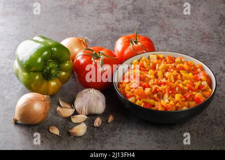 Hausgemachte frische Sofrito-Sauce aus Sommergemüse in einer Schüssel auf dem Tisch. Horizontal Stockfoto