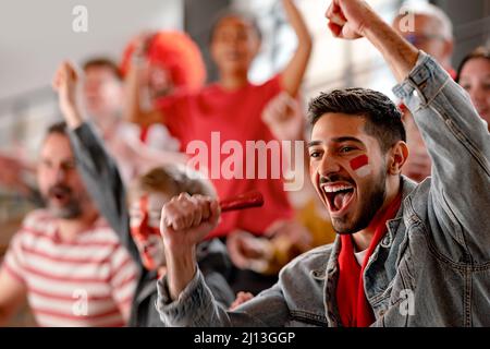 Begeisterte Fußballfans, die die österreichische Nationalmannschaft in einem Live-Fußballspiel im Stadion unterbinden. Stockfoto