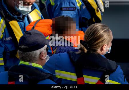 ANMERKUNG DER REDAKTION: Das Gesicht des Kindes wurde verpixelt, da das PA Picture Desk nicht die erforderliche Erlaubnis erhalten hat, ein Kind unter 16 Jahren über Fragen ihres Wohlergehens zu fotografieren. Ein Küstenwache-Offizier trägt ein kleines Baby, da eine Gruppe von Menschen, die als Migranten gelten, von einem Schiff der Grenzstreitkräfte nach Dover, Kent, gebracht wird, nachdem ein kleines Boot im Kanal vorkam. Bilddatum: Dienstag, 22. März 2022. Stockfoto