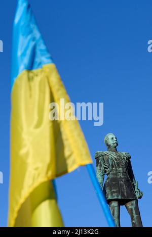 Helsinki, Finnland - 26. Februar 2022: Statue des ehemaligen russischen Zaren Alexander II und ukrainischer Flagge bei einer Kundgebung gegen die russischen Militärankaten Stockfoto