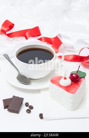 Tasse mit Kaffee und Kuchen in Form eines Herzens mit Kirschen, Schokolade Stockfoto